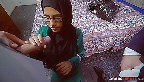 A hot white girl sucks two big white cocks on her knee